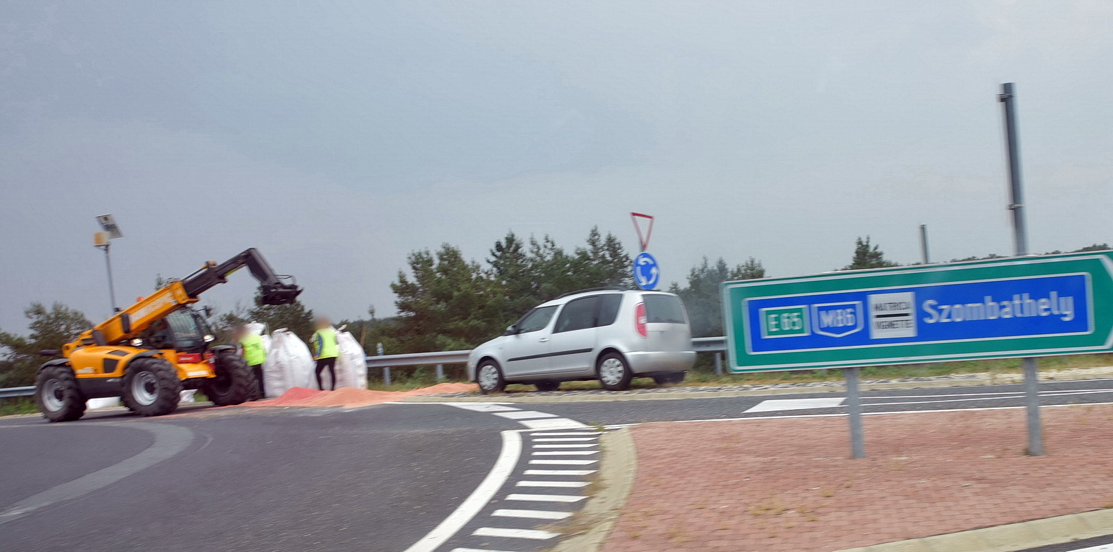 Munkagép segíti a rakodást a 88-as főúton, az M86-os csomópont körforgalmában