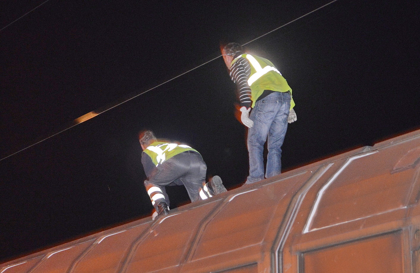 A kép 2013-ban készült, amikor egy vagonra mászó fiatal 25 Kv-os vezeték alatt egyenesedett fel és életveszélyesen megsérült. A fotón vasúti munkások láthatók a baleset után. Fotó: 112Press