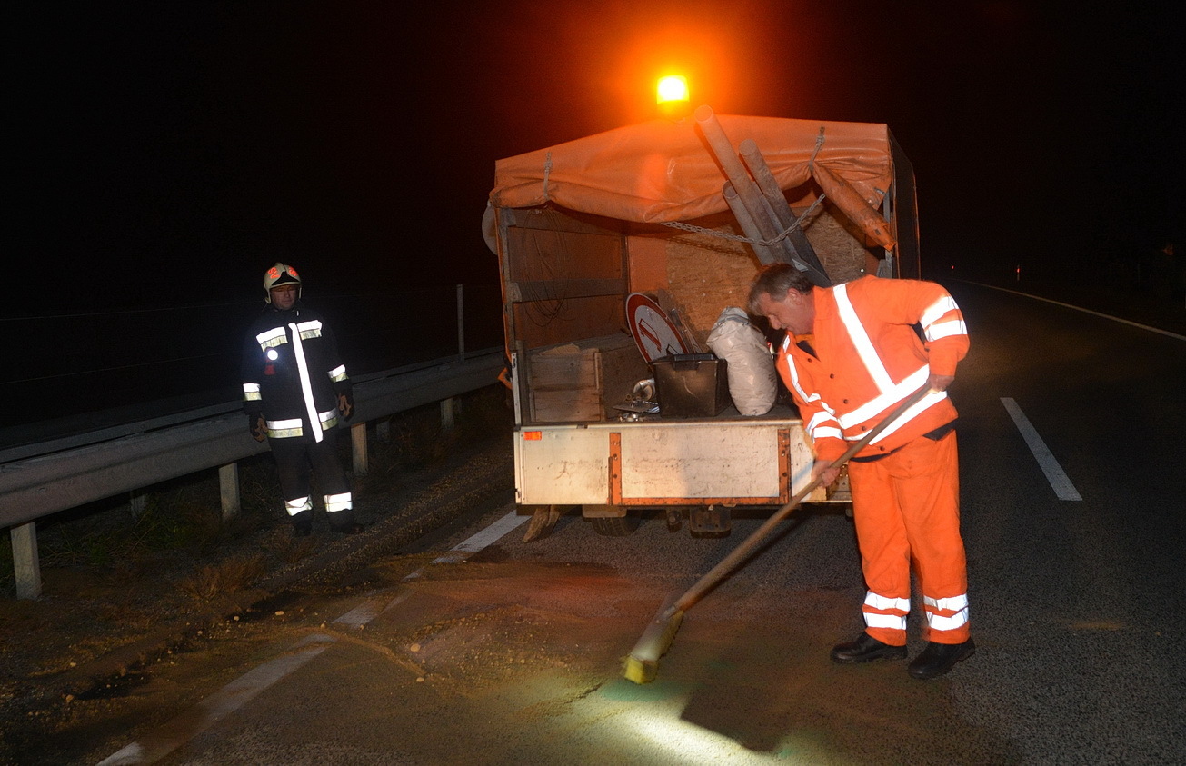 A Közút munkatársa az utat takarítja