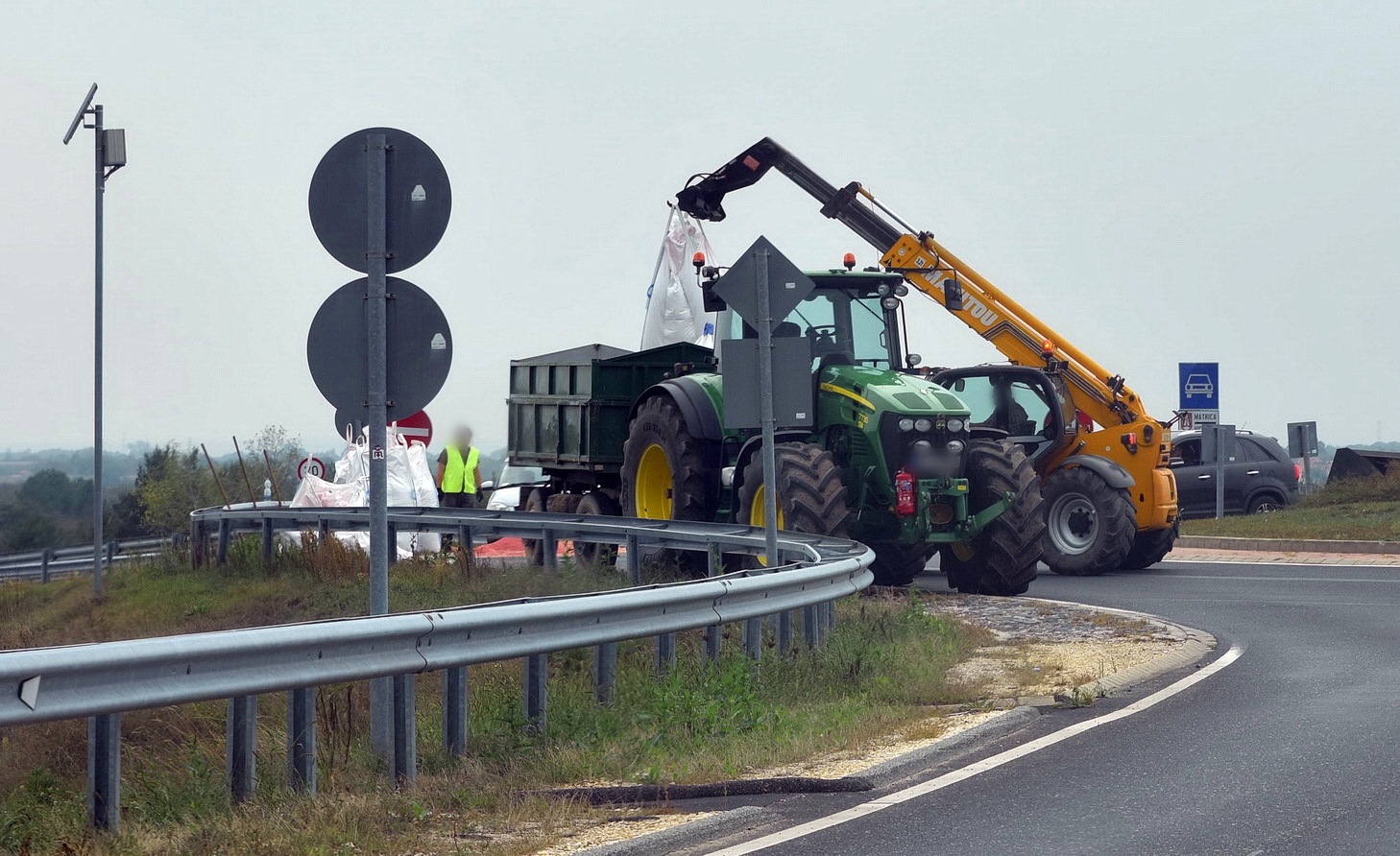 Munkagép segíti a rakodást a 88-as főúton, az M86-os csomópont körforgalmában